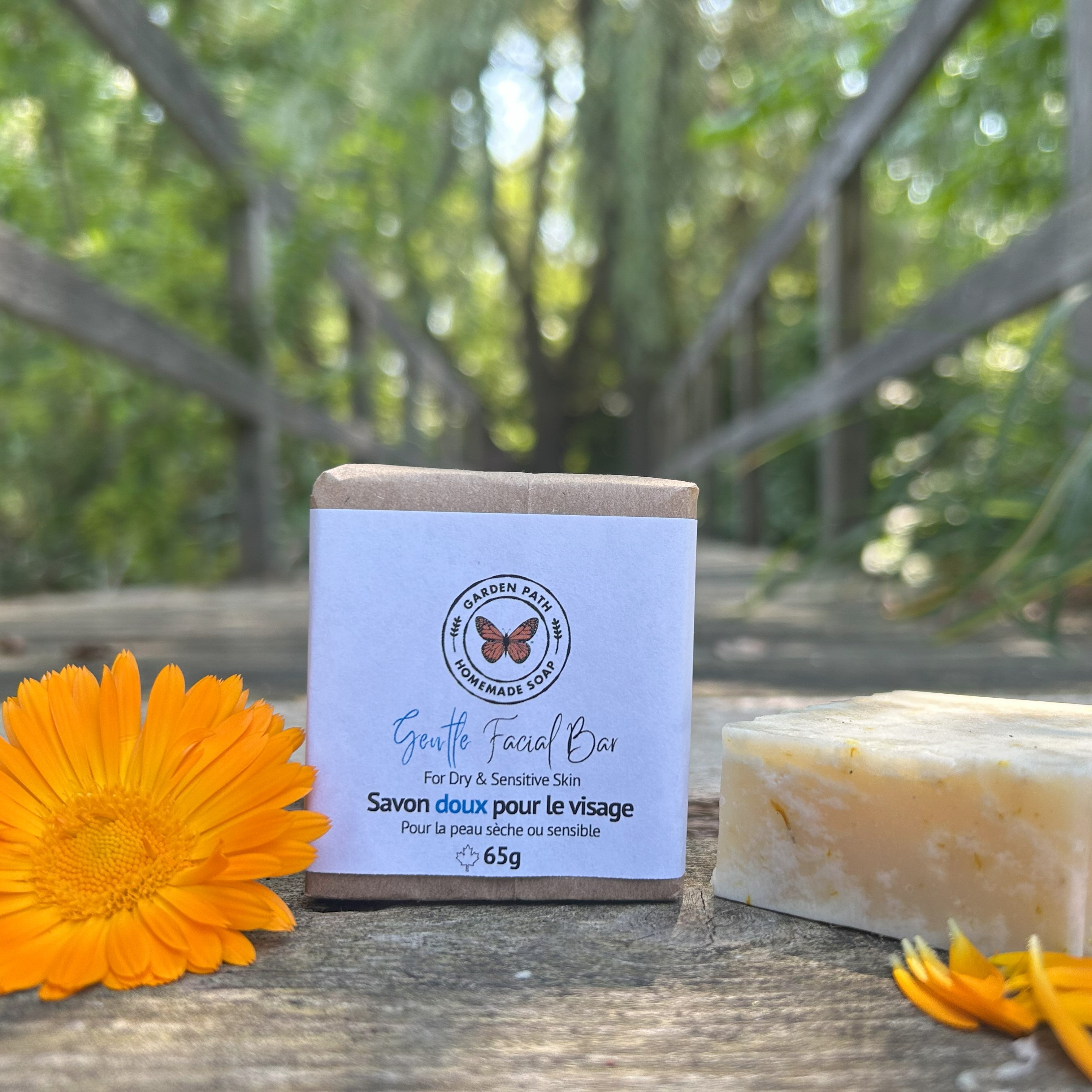 Gentle Facial Bar of soap beside a calendula orange flower on a wooden surface by Garden Path Homemade Soap. Soap for Dry, Sensitive Skin | 100% Natural Ingredients