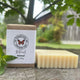 Patchouli Bar of soap and its packaging with 'Garden Path Homemade Soap' branding on a wooden surface outdoors. 100% Natural Soap with Essential Oil