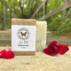 Rose Petal bar of soap with a 'Garden Path Homemade Soap' label, surrounded by red roses on a natural surface. Lightly Scented Fragrance