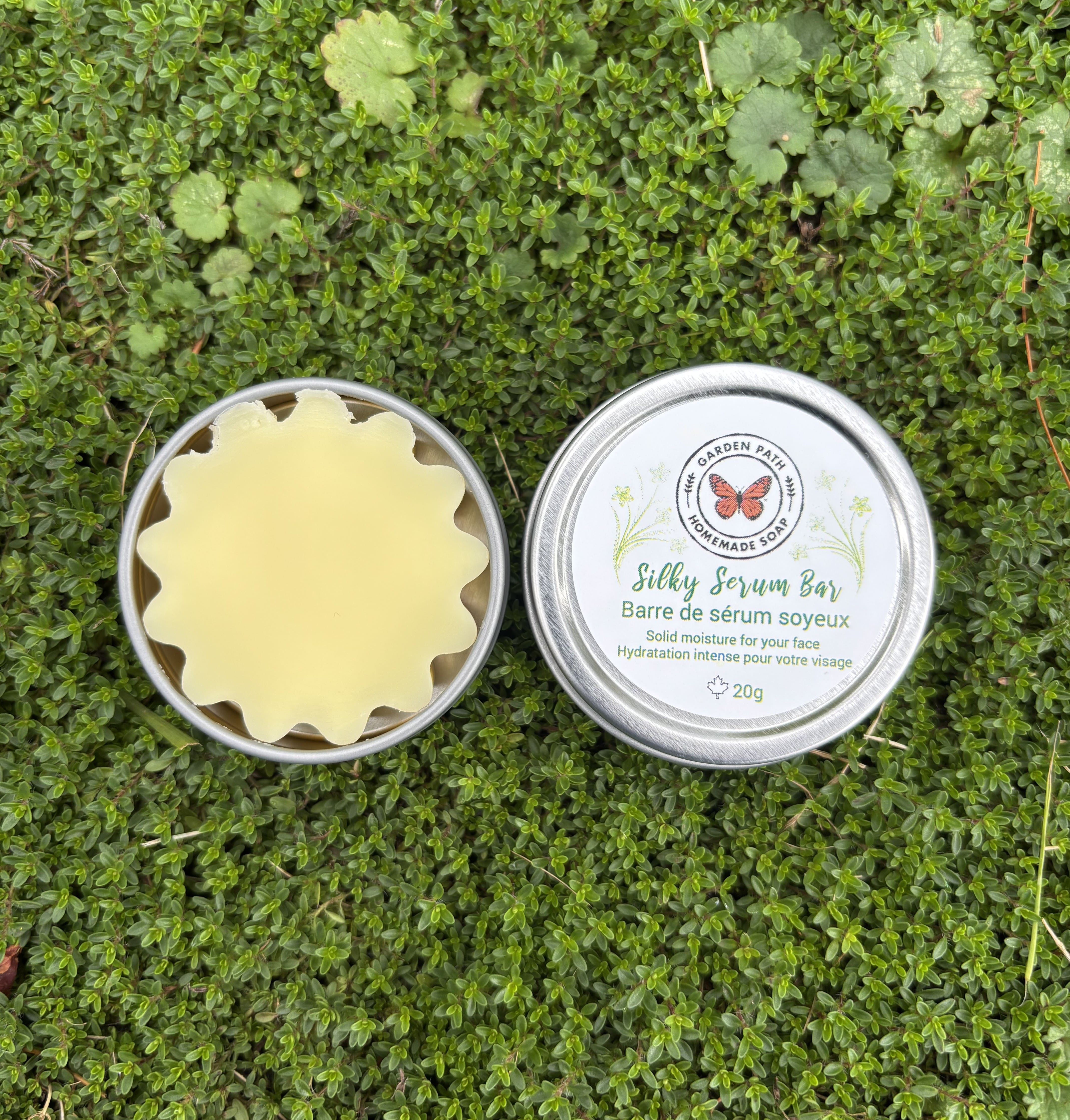 Silky Serum Bar in a metal container on green grass by Garden Path Homemade Soap . 100% Natural Ingredients