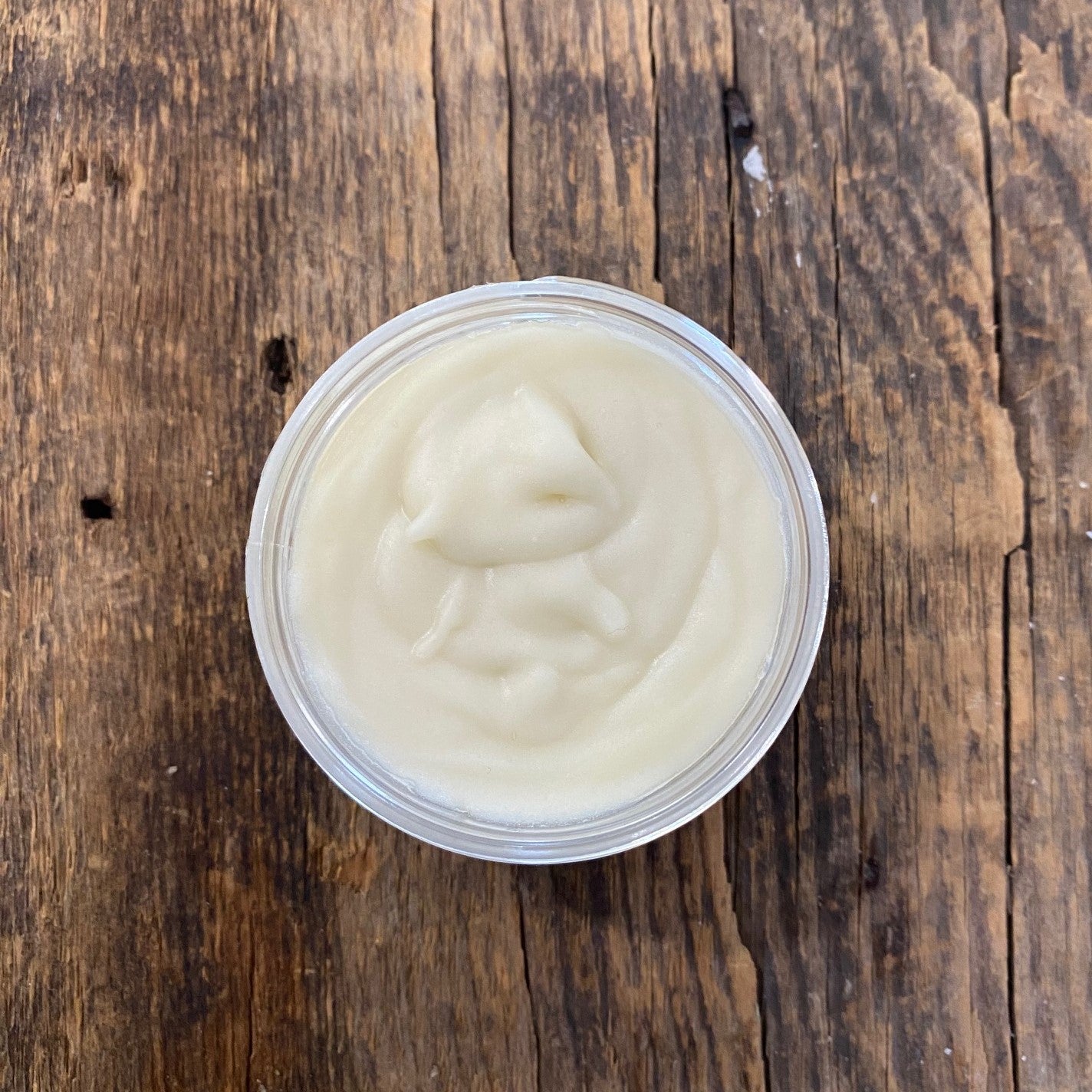 Opened jar of Green Tea Face Cream on a wooden surface by Garden Path Homemade Soap. 100% Natural Ingredients
