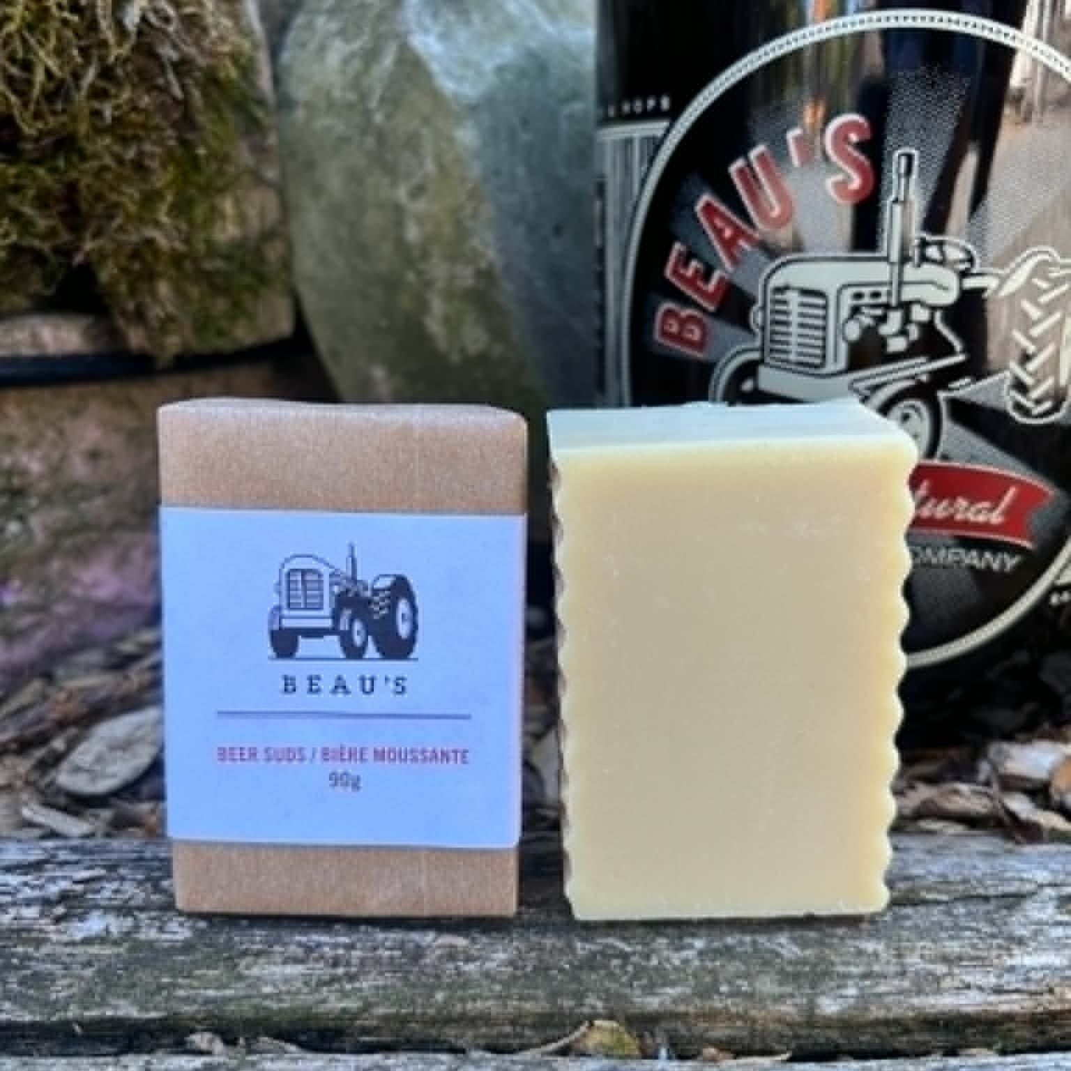 Beau's Beer Suds Bar of soap with a  bottle of Beau's beer on a wooden surface by Garden Path Homemade Soap.  100% Natural . Made with Beau's Beer