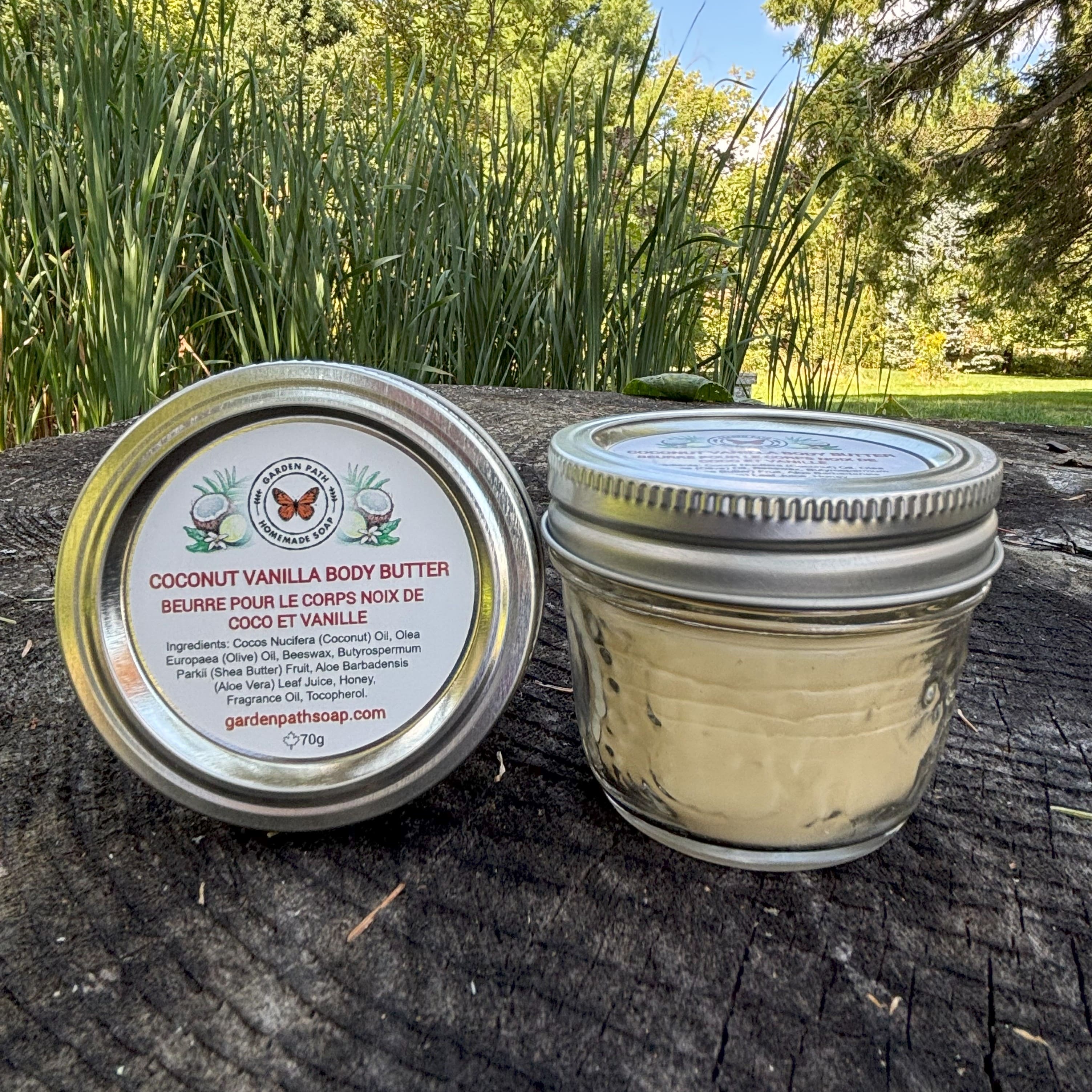 Jar of Coconut Vanilla Body Butter on a stump outdoor natural setting by Garden Path Homemade Soap