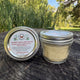 Jar of Coconut Vanilla Body Butter on a stump outdoor natural setting by Garden Path Homemade Soap