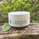 Green Tea Face Cream on a log outdoor setting by Garden Path Homemade Soap. 100% Natural Ingredients