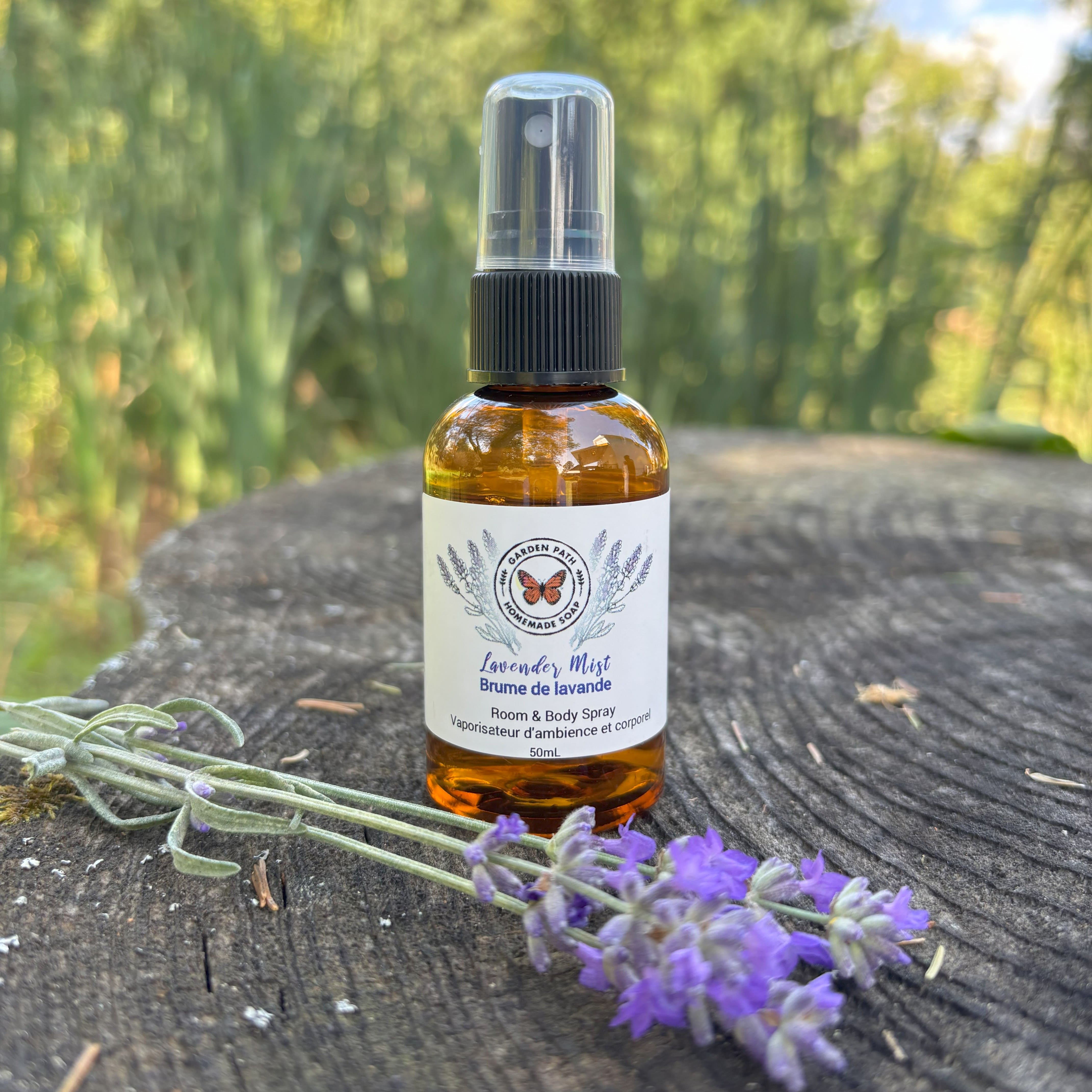 Garden Path Homemade Soap's Lavender Mist body sprayer sitting on a wooden surface with a sprig of lavender  -  100% Natural Essential Oil