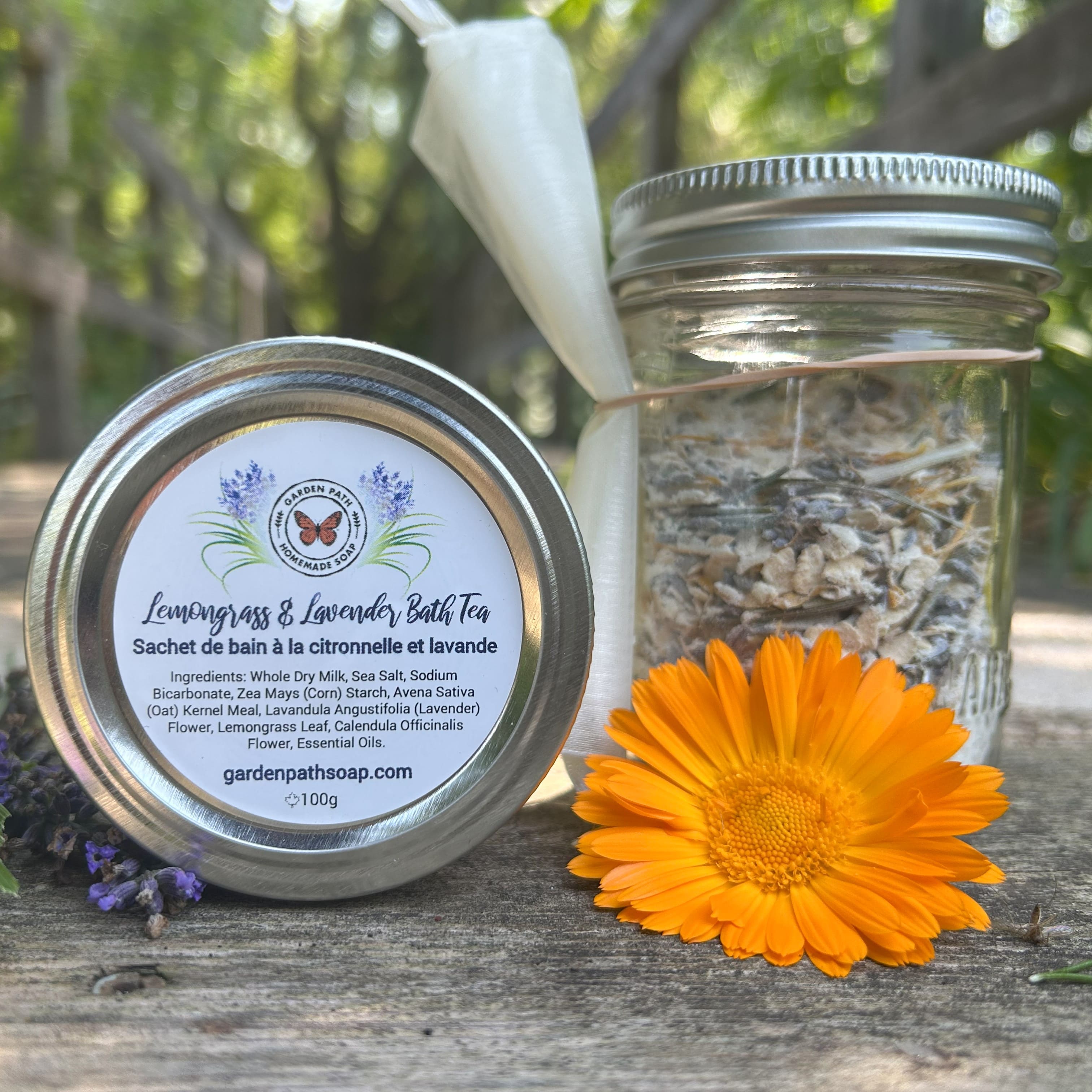 Lemongrass & Lavender Bath  Tea packaging with a glass  jar and orange flower on a wooden surface