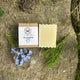 Outdoor Shampoo Bar of soap and packaging on a stone surface with greenery and flowers by Garden Path Homemade Soap