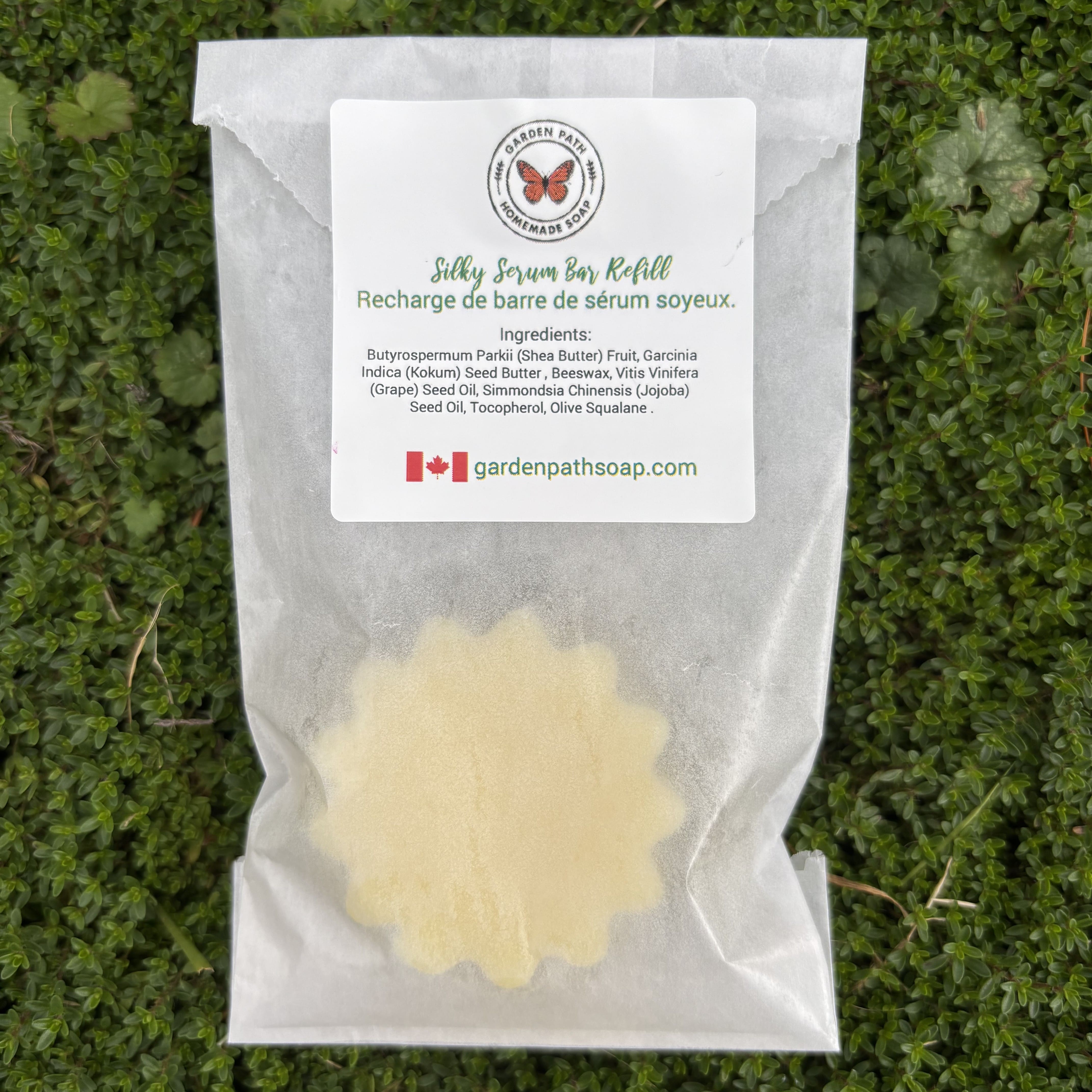 Silky Serum Bar Refill packaging with a label on a grass background. Garden  Path Homemade Soap - 100% Natural Ingredients