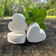 3 heart shaped Foot Fizzes on a wooden surface with peppermint springs by Garden Path Homemade Soap. 100% natural ingredients